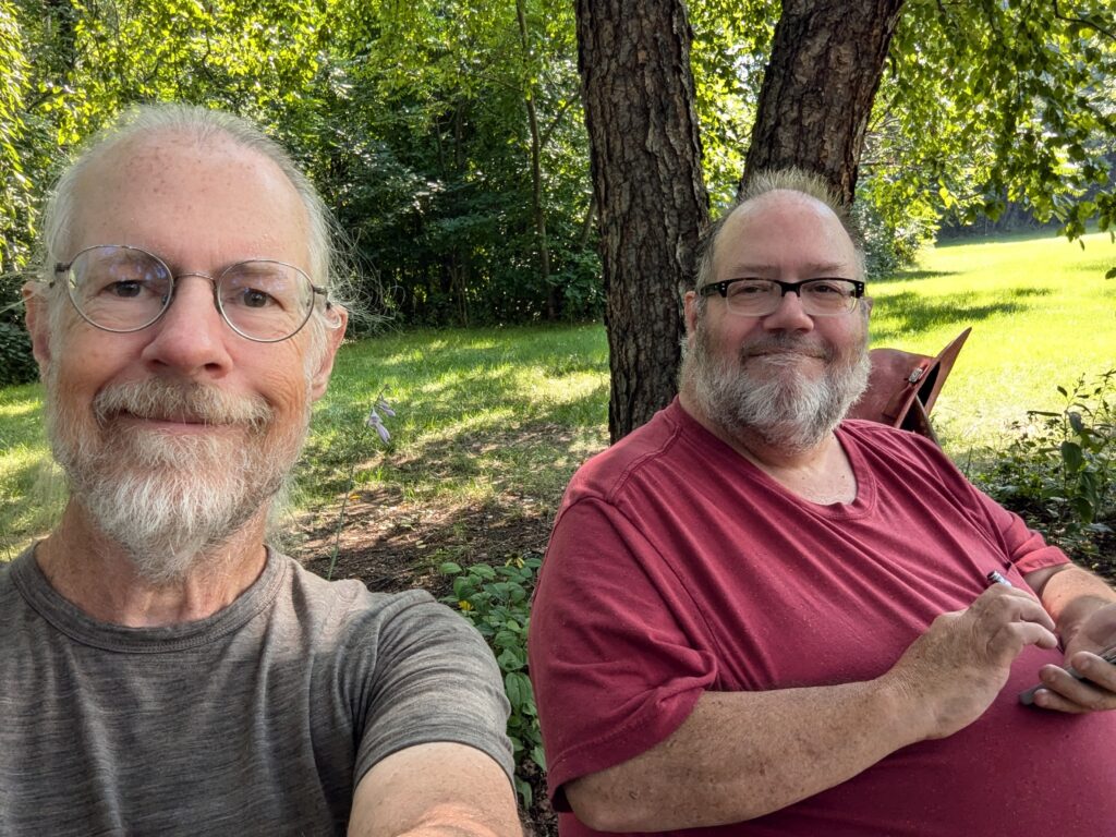 Me and my brother, sitting on a bench in a pollinator garden