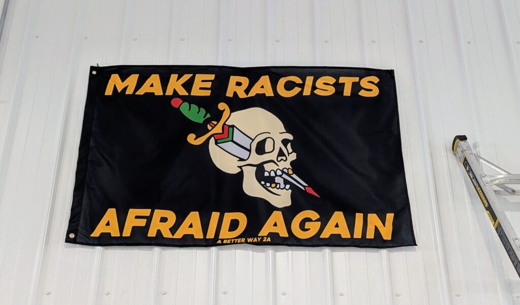 Banner showing a skull with a dagger through it, with the text "Make racists afraid again"