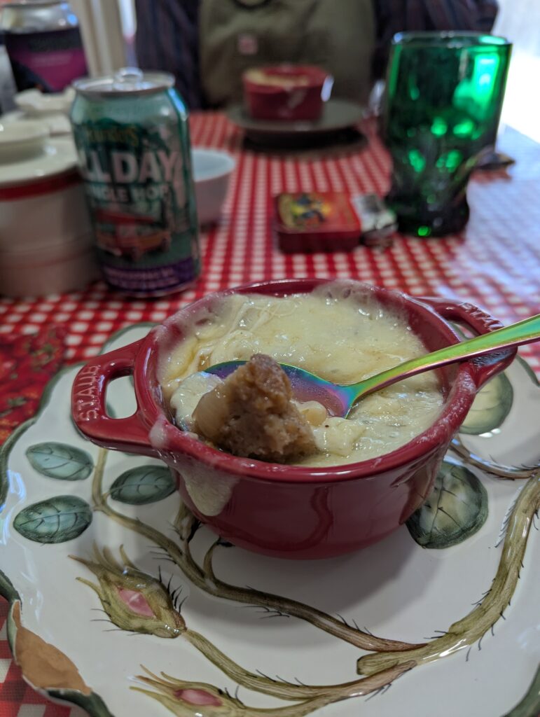 A bowl of French onion soup with a spoonful of broth, onions, and crouton turned up on the cheese